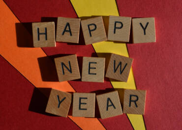 Happy New Year, phrase in wooden alphabet letters on bright and colourful background